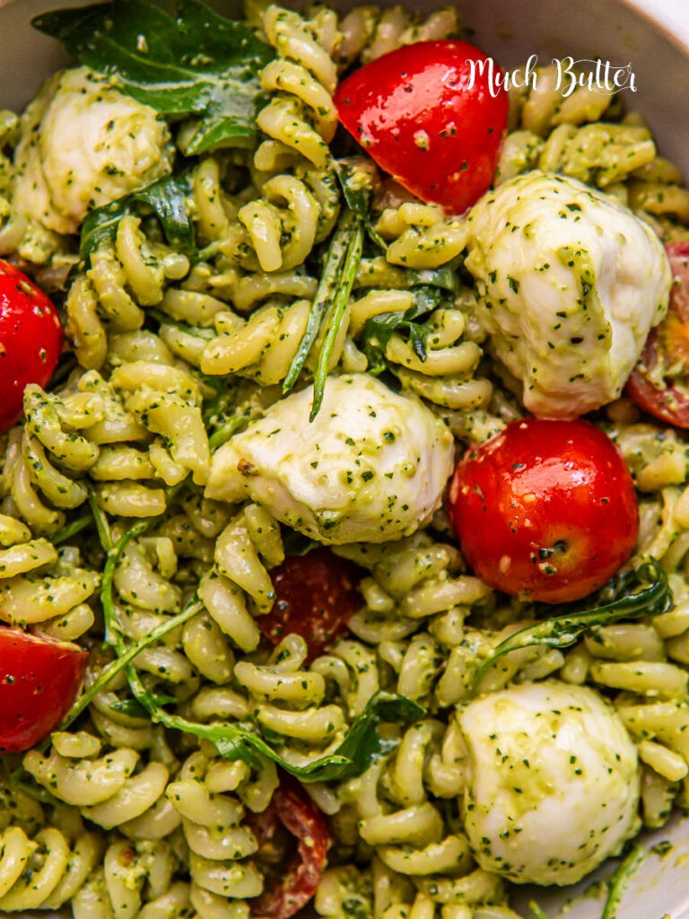 A vibrant photo of wholesome wheat pasta tossed with vibrant green pesto and juicy cherry tomatoes.