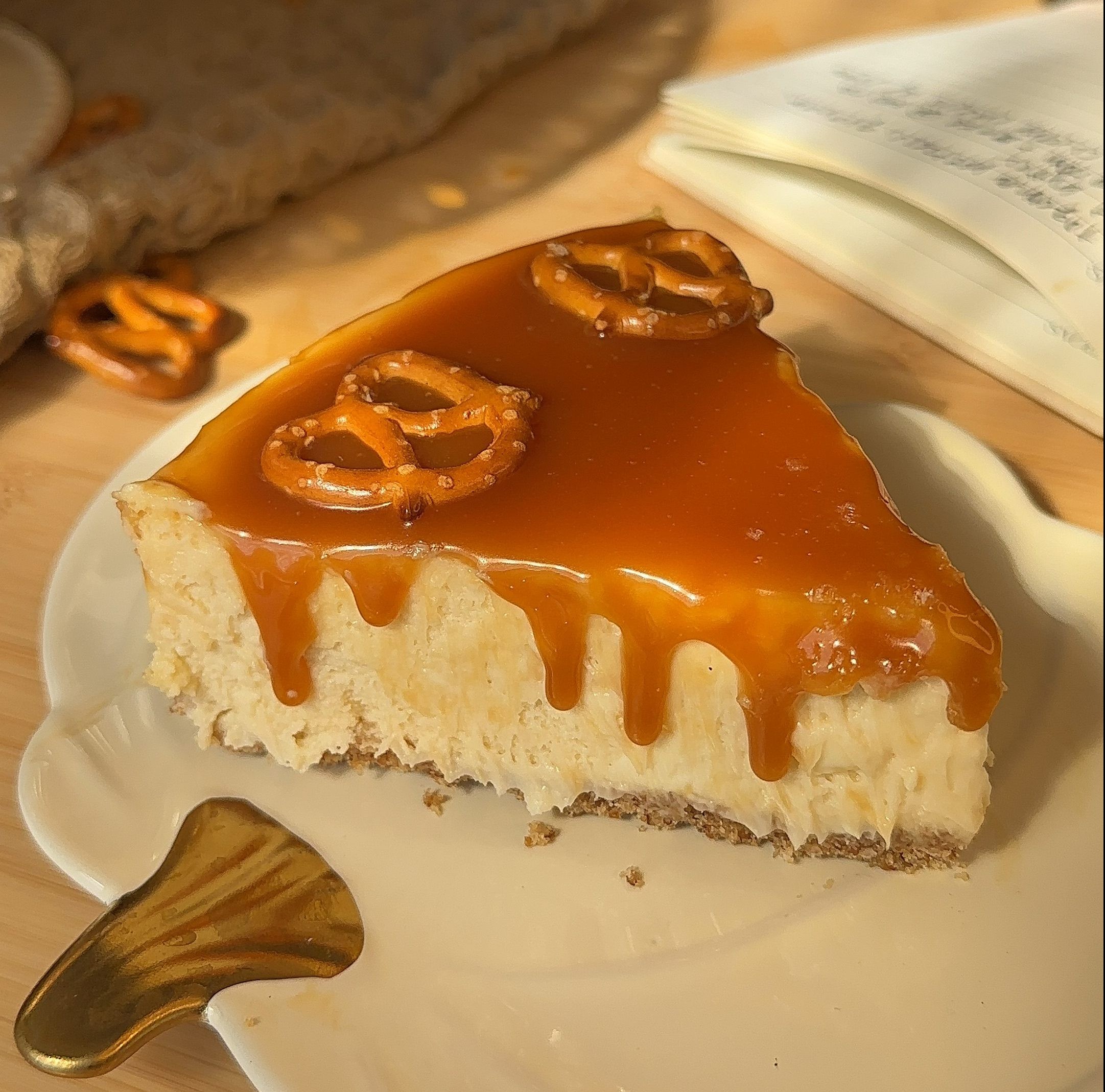 A slice of salted caramel pretzel cheesecake with pretzels and caramel drizzle on top