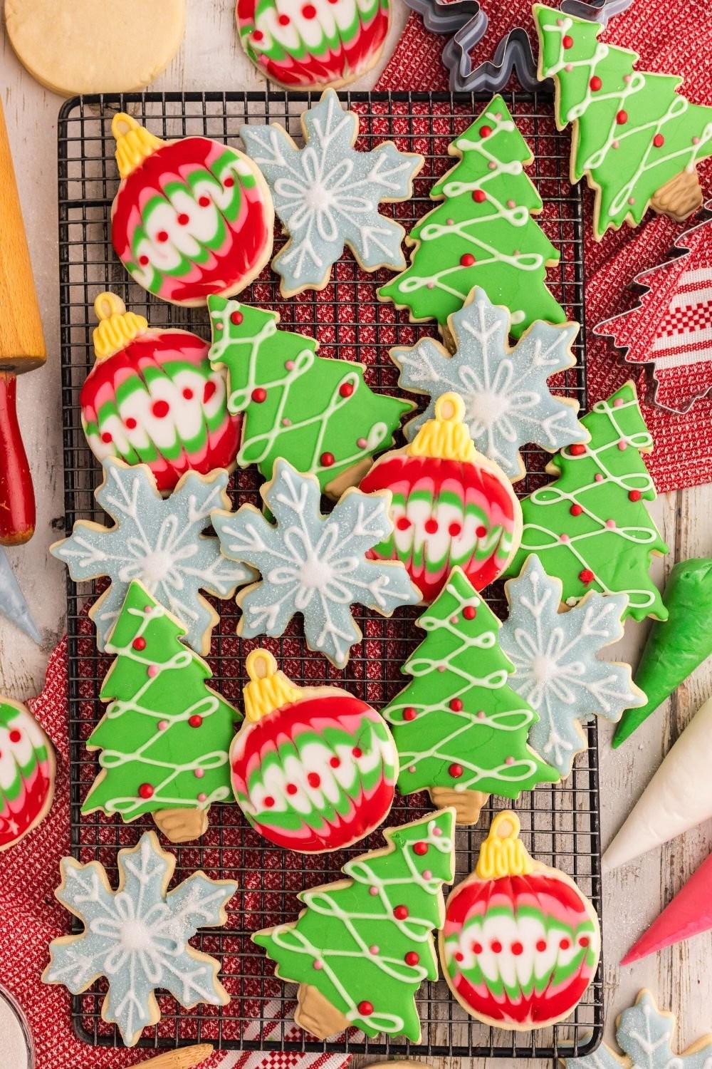 Assortment of beautifully decorated holiday sugar cookies with royal icing on a cooling rack