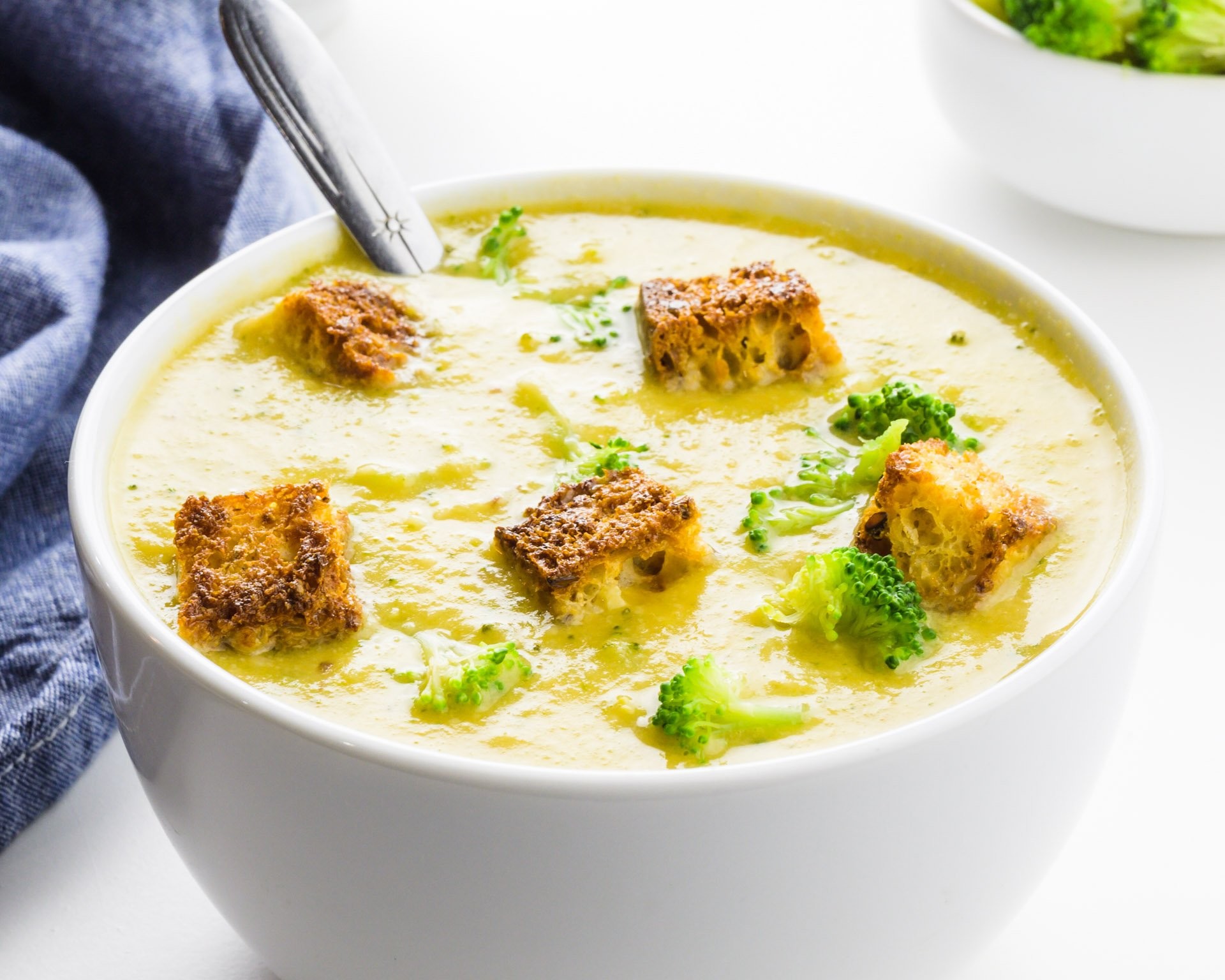 bowl of vegan cheddar broccoli soup with croutons