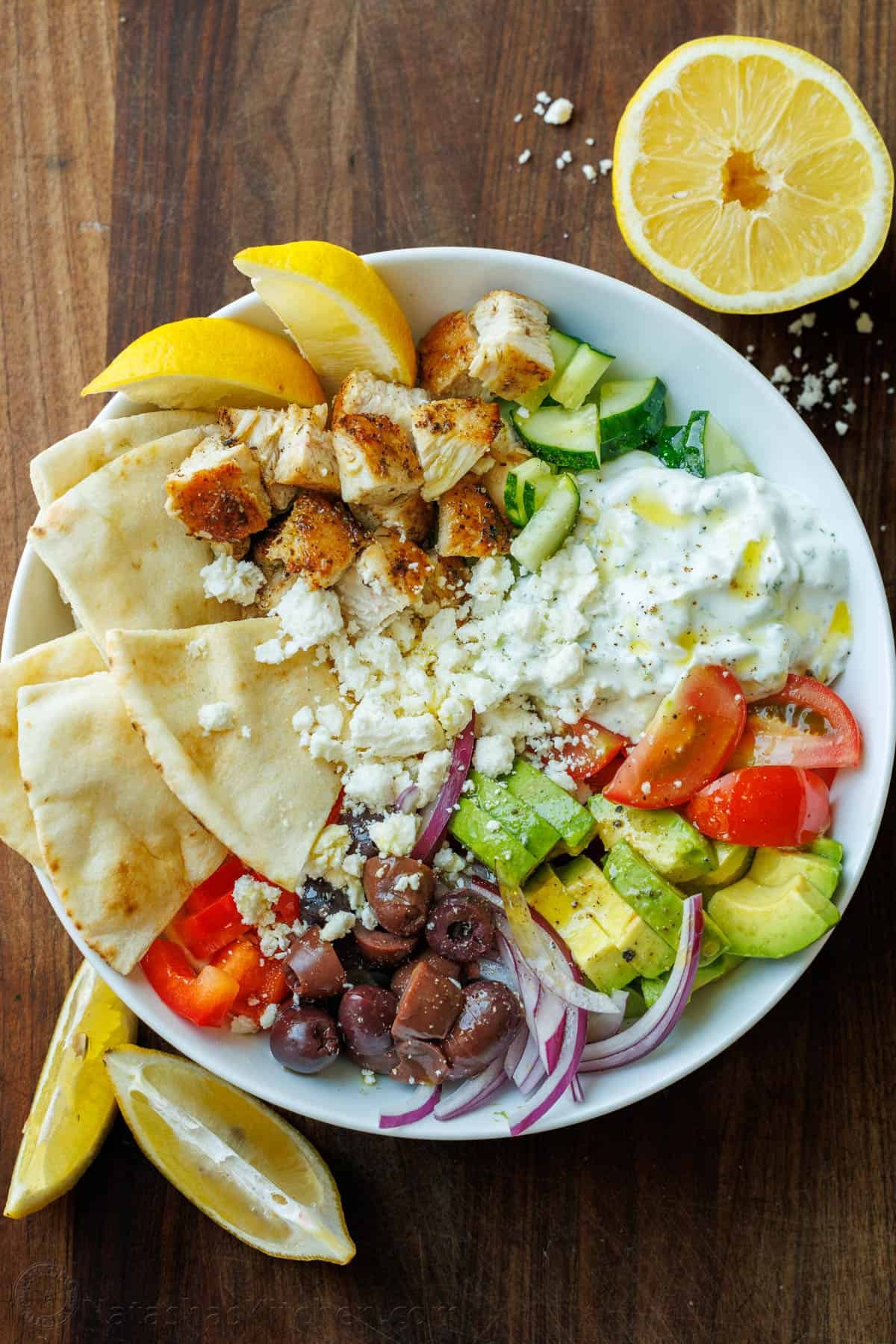 Vibrant Greek chicken bowls with tzatziki, fresh vegetables, and feta cheese, bright lighting, healthy food blog style