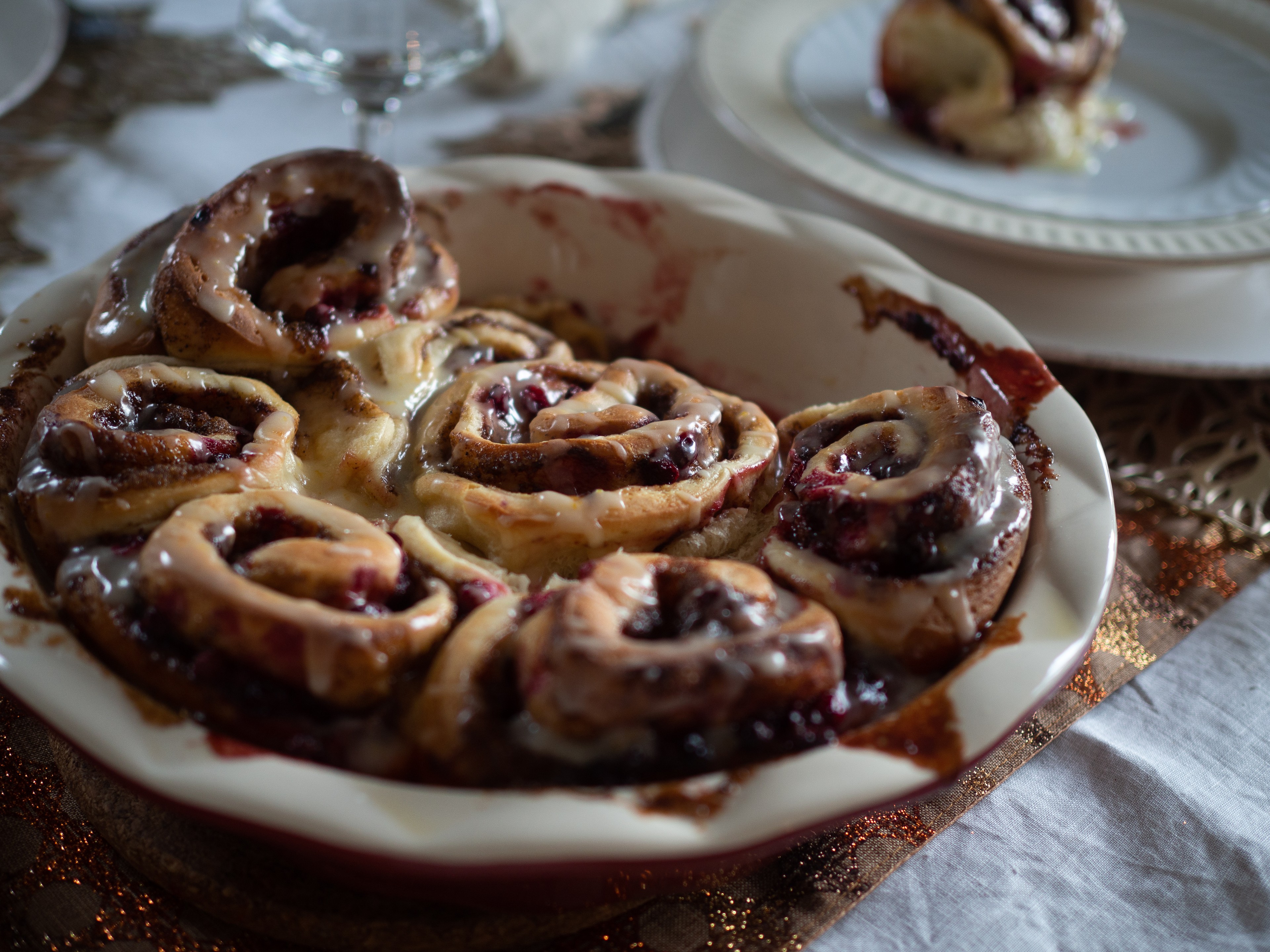 freshly baked lingonberry and cinnamon rolls on a rustic wooden board