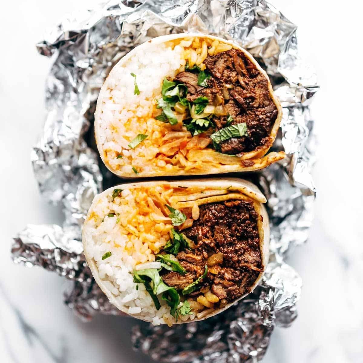 A delicious Korean BBQ Sushi Burrito, cut in half to show the filling, with a vibrant and appetizing presentation