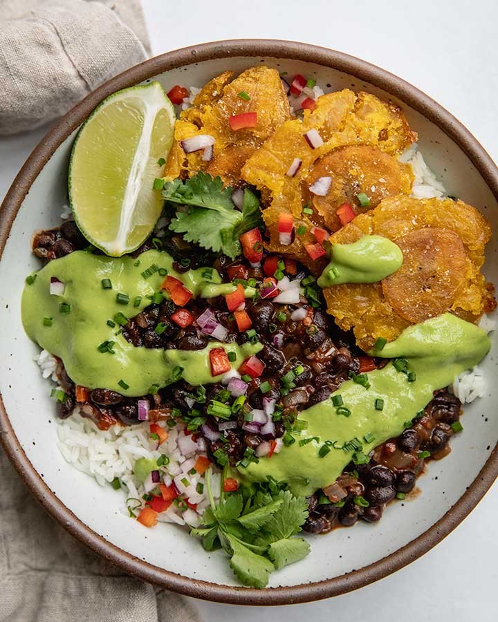 A vibrant and colorful Chipotle Lime Chicken & Black Bean Protein Bowl, garnished with fresh cilantro and lime wedges, ready to be eaten.