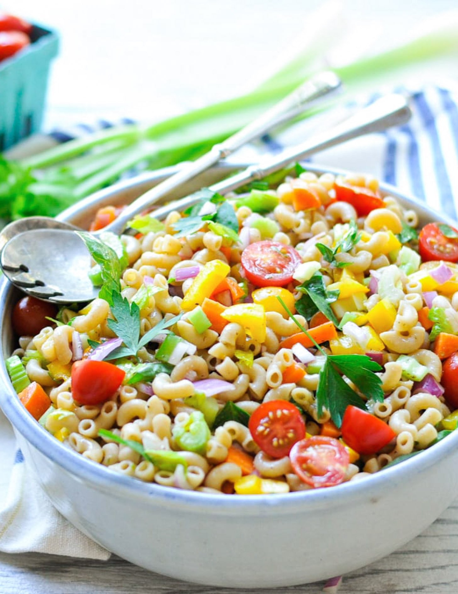 A close-up shot of a vibrant macaroni salad with celery, showing the creamy dressing and fresh ingredients.