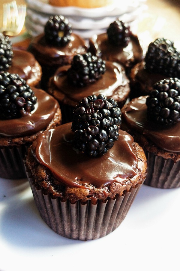 Close-up shot of gooey brownie bites with a blackberry swirl, garnished with fresh blackberries.