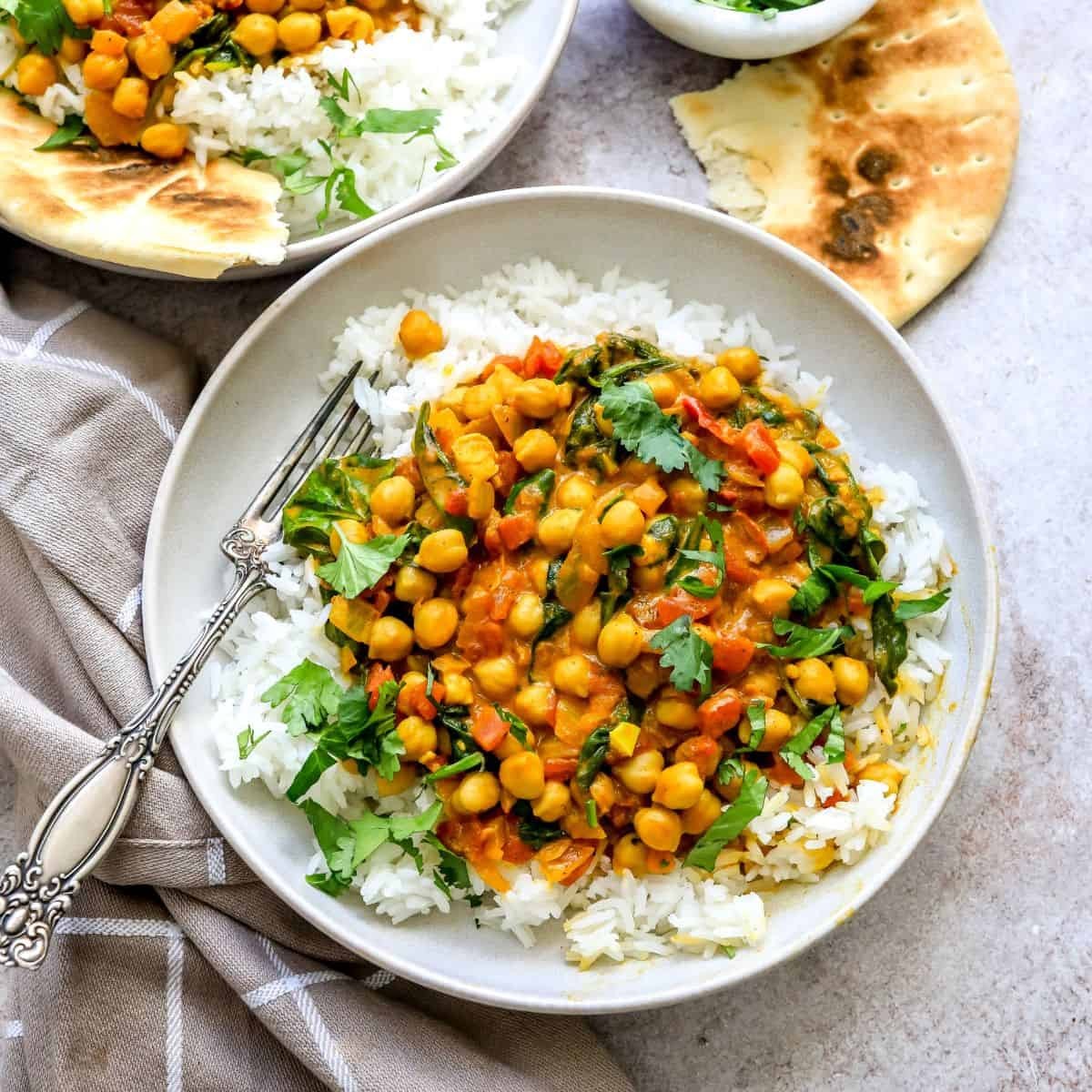Delicious chickpea spinach curry in a rustic bowl with basmati rice, garnished with fresh cilantro