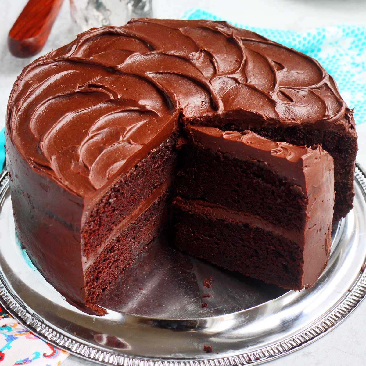 Close-up shot of a moist, maroon-colored cake with a rich, glossy glaze