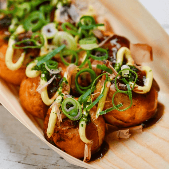 Herring Takoyaki on a plate, garnished with green onions and sauce