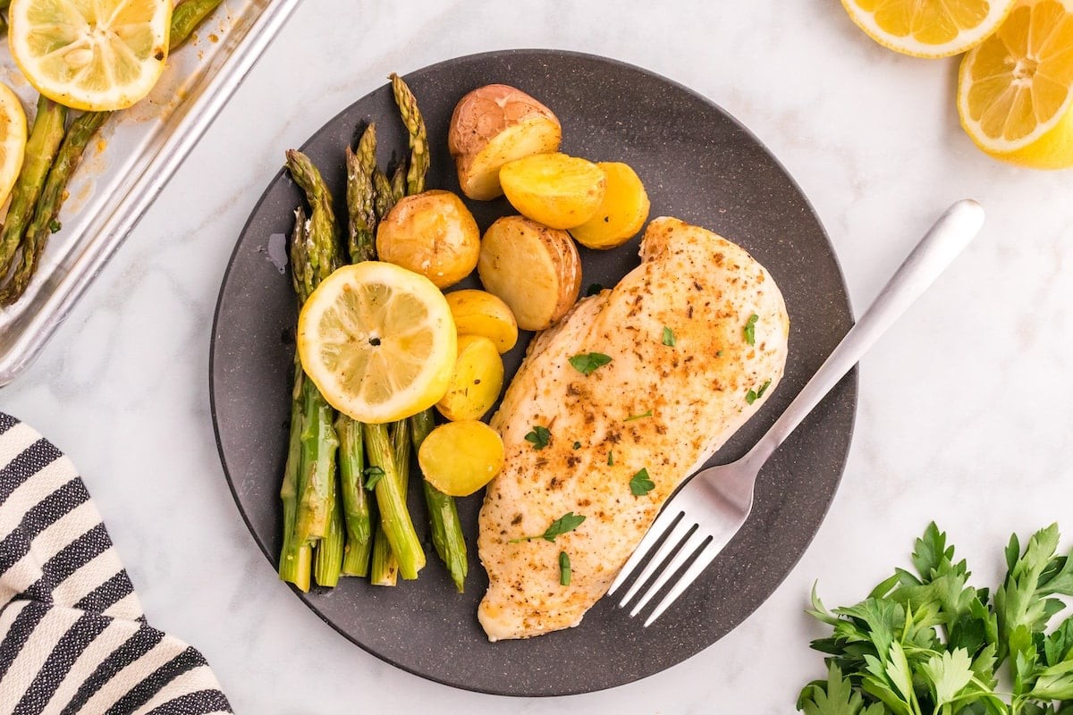vibrant pan-seared citrus garlic chicken breast on a plate with fresh herbs and lemon wedges