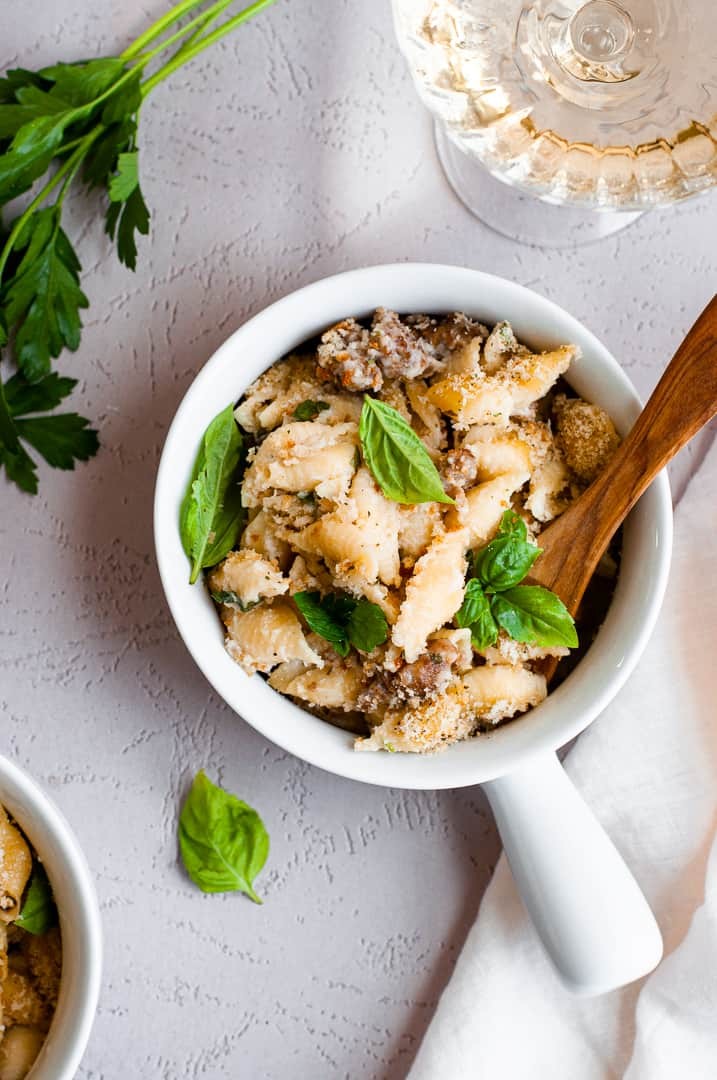 Vibrant, bubbling Italian mac and cheese in a rustic pot, garnished with fresh basil leaves and a sprinkle of Parmesan