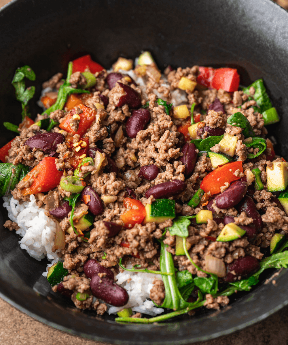 Vibrant chili-glazed beef bowl with rice and fresh toppings