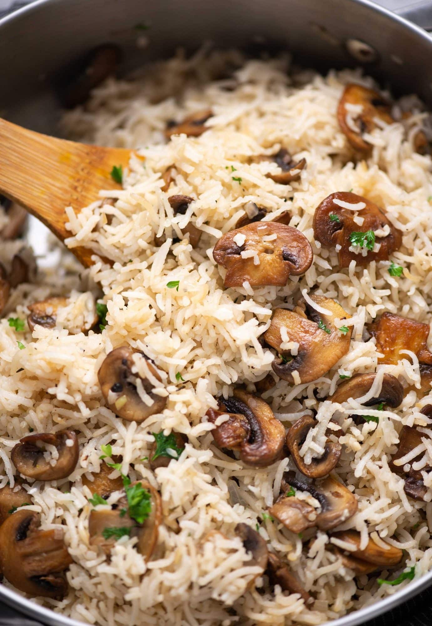 A close-up shot of a bowl of boiled rice with mushrooms and thyme
