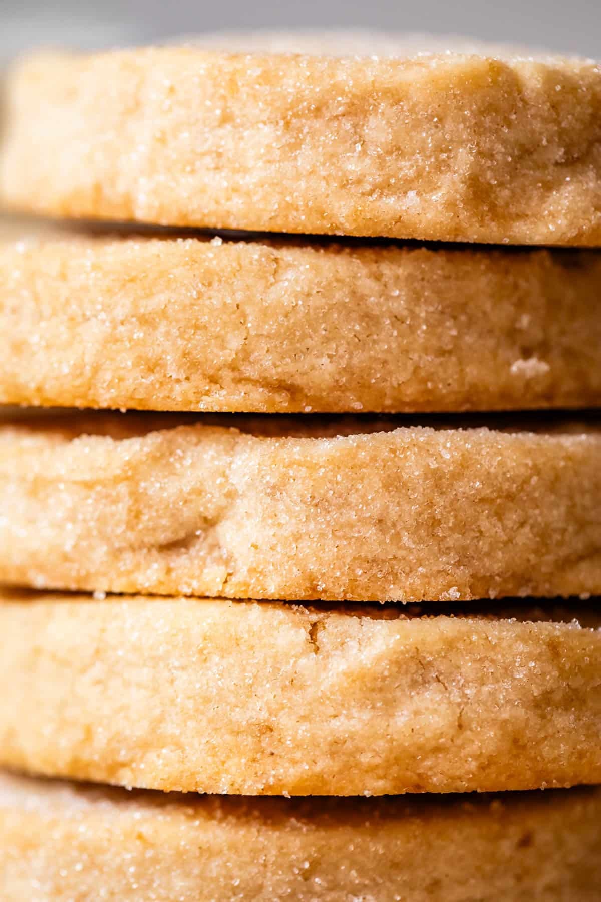 Golden brown classic shortbread cookies on a cooling rack with crumbs, close up