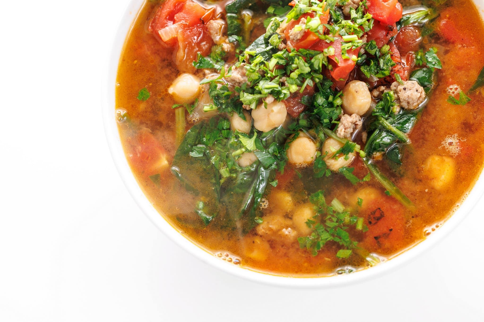 A hearty lamb stew with chickpeas and spinach in a rustic pot