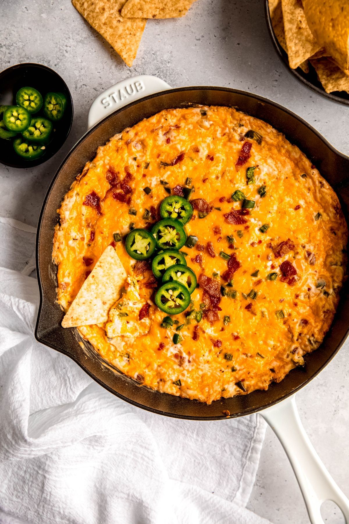 Creamy baked jalapeño popper dip with crispy topping and tortilla chips