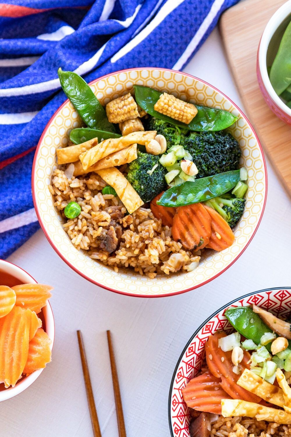 A beautiful, colorful veggie stir-fry bowl with chopsticks, healthy and fresh ingredients visible.