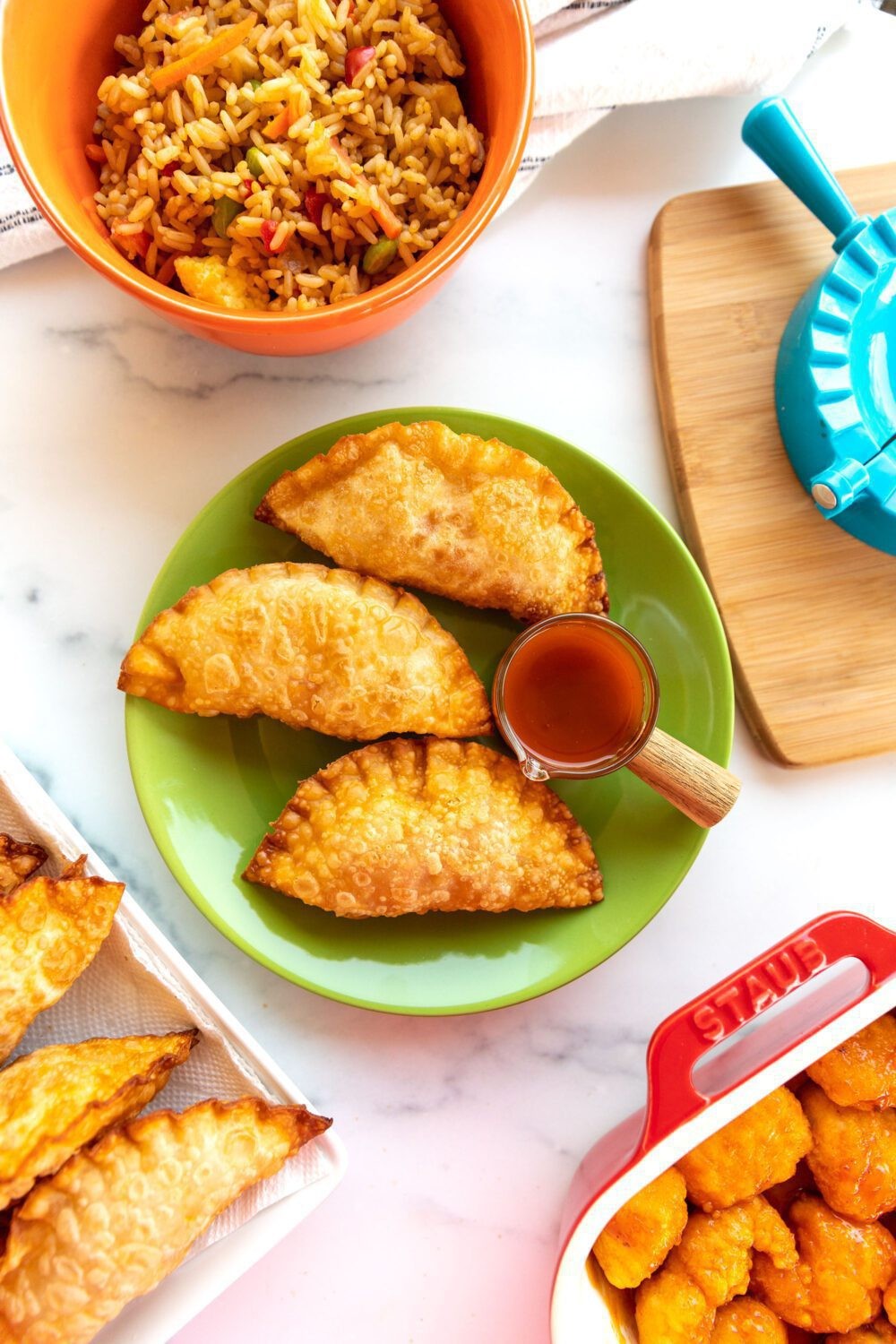 teal empanadas with orange garnish