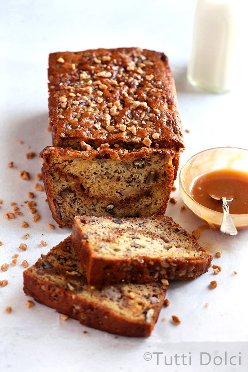 warm slice of banana toffee bread with melting toffee bits, a cozy kitchen background