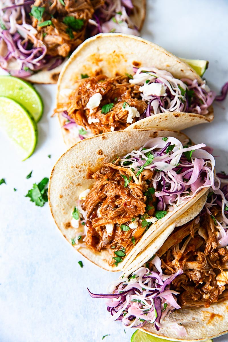 slow cooker pulled pork street tacos topped with cilantro and onion