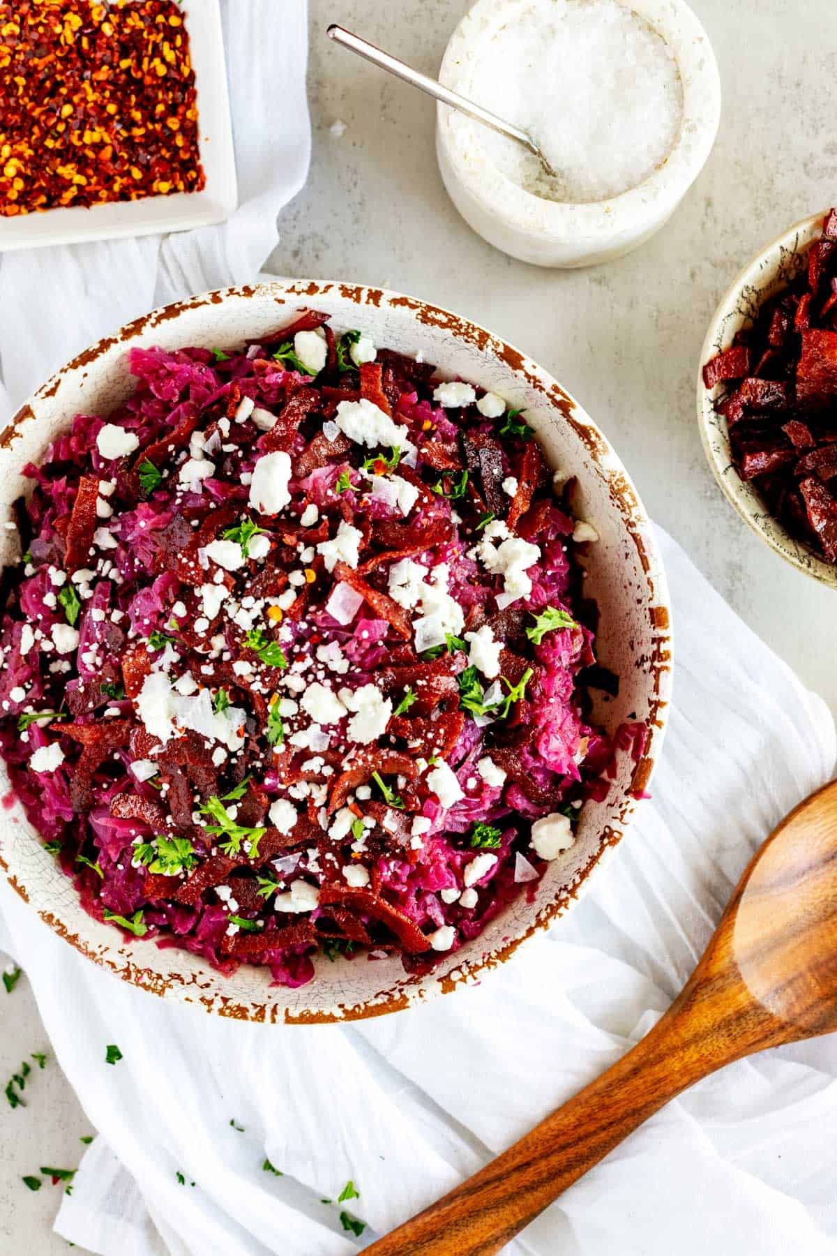 Vibrant braised red cabbage with sweet apples and a subtle tang, garnished with fresh herbs, rustic setting