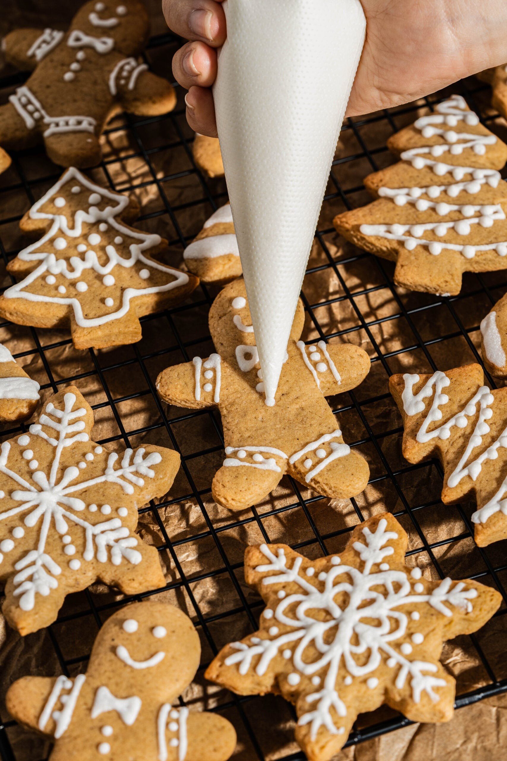 beautifully frosted thick gingerbread cookies on a cooling rack, cozy kitchen setting