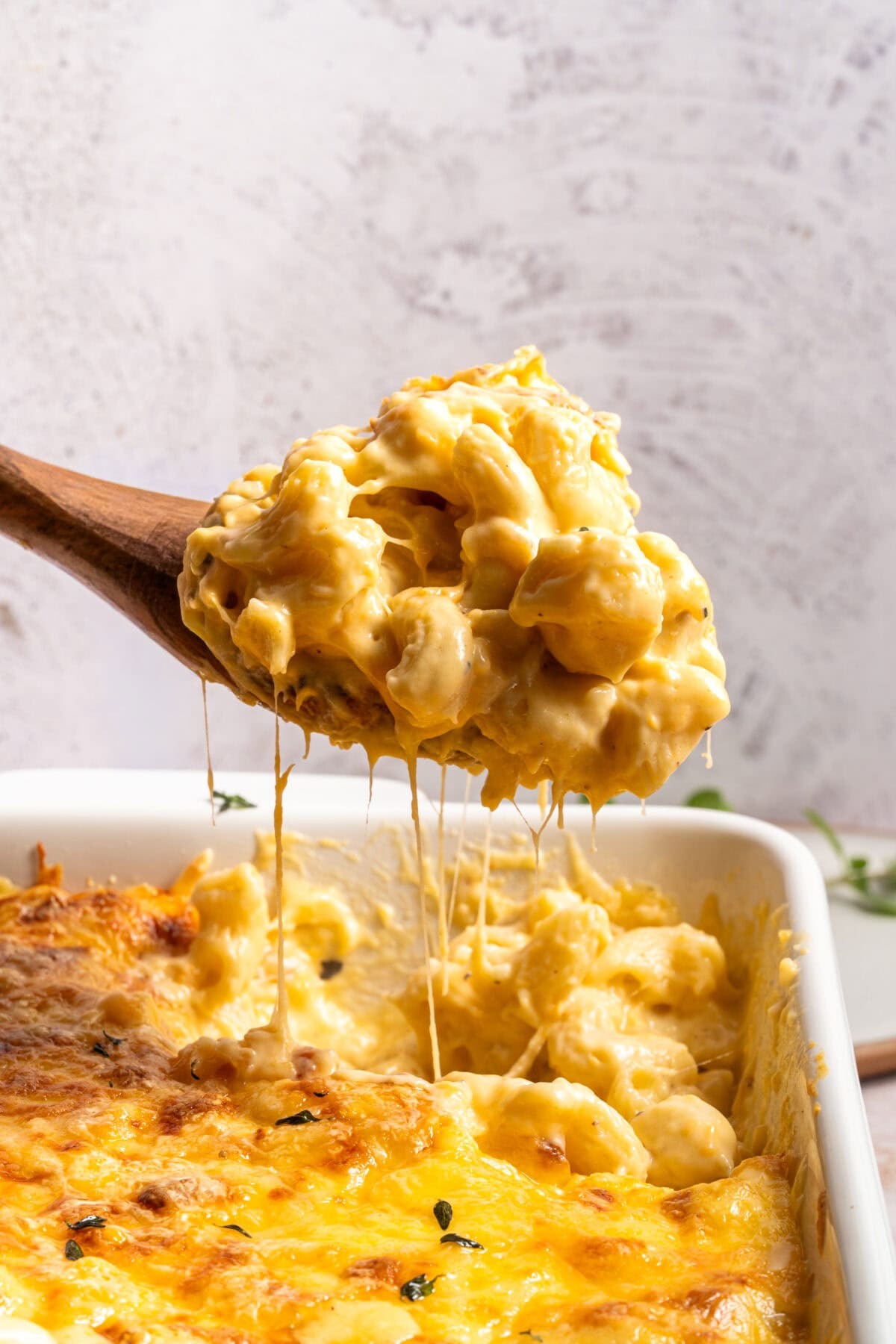 Creamy baked mac and cheese close up with golden crust, comfort food, cozy kitchen lighting