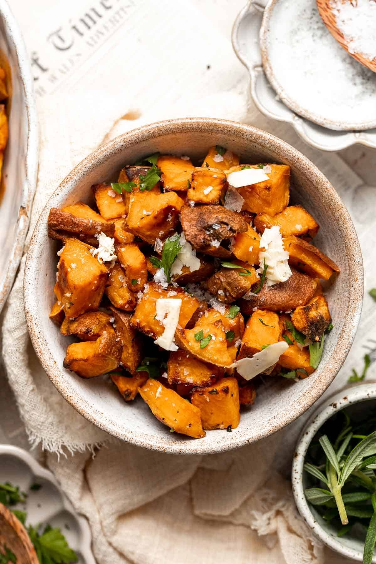 close-up shot of roasted sweet potatoes with herbs and spices, kwanzua setting in background