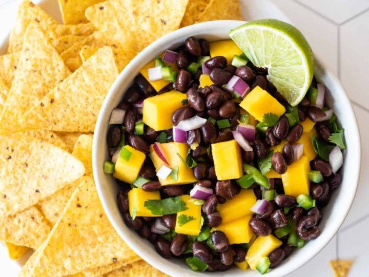 close up shot of black bean and mango salsa with plantain chips