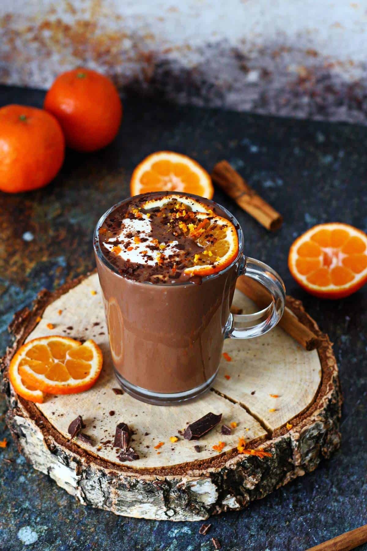 mug of orange infused hot chocolate with orange zest garnish, cozy winter setting, warm lighting