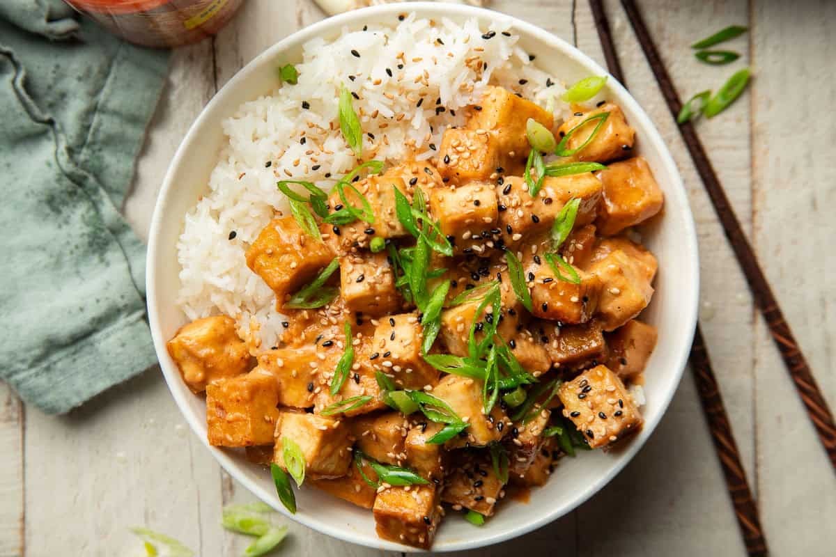stack of sriracha glazed tofu sliders with sesame seeds and green onions