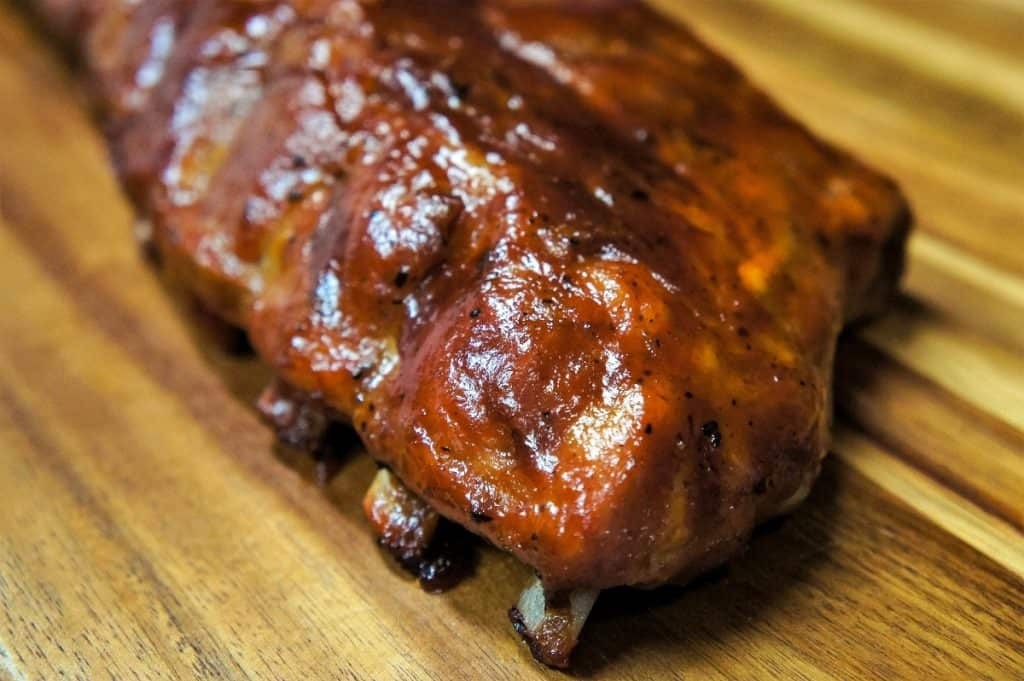 Smoked ribs with pineapple habanero salsa on a rustic wooden board