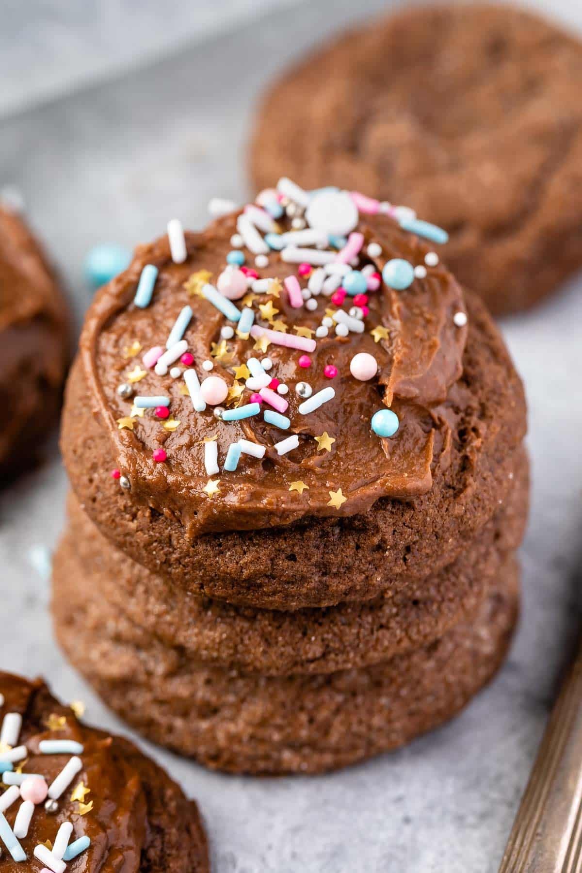 Delicious fudgy cocoa sugar cookies stacked on a plate with a dusting of powdered sugar, warm inviting kitchen background.