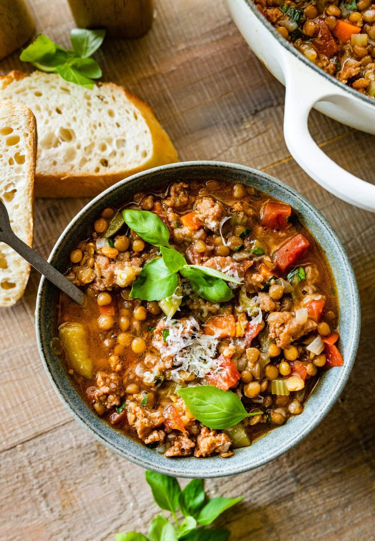 a bowl of hearty one-pot lentil soup with sausage, garnished with fresh herbs