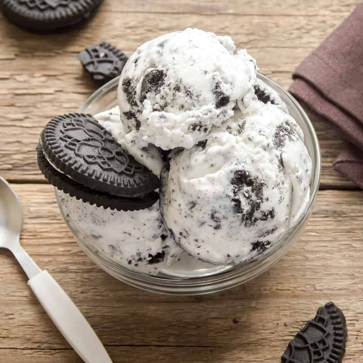 A scoop of homemade cookies and cream ice cream in a bowl, with crushed Oreos on top