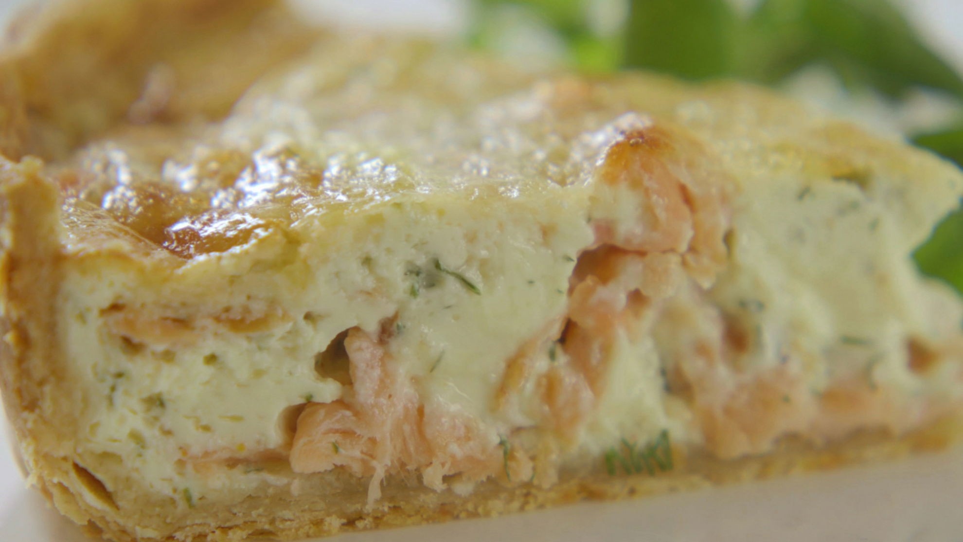 Smoked salmon and dill tart on a white background