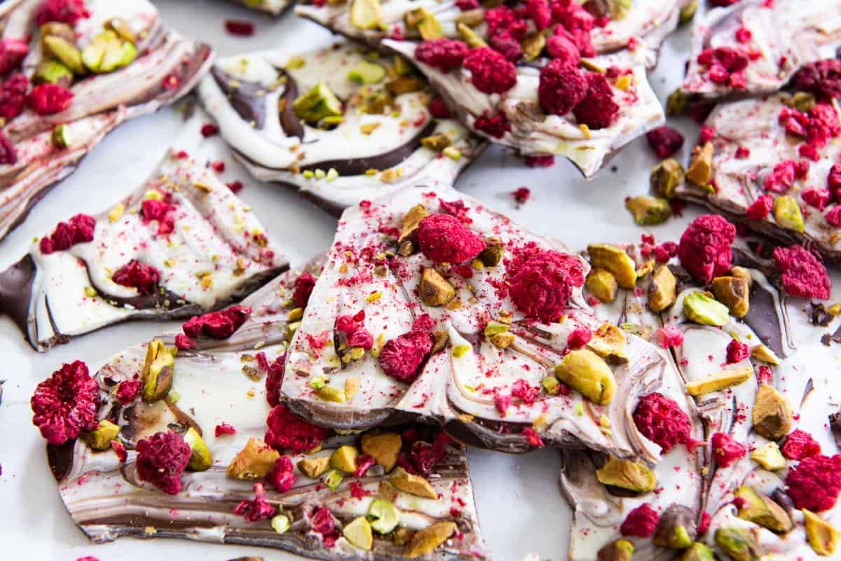 Homemade swirled chocolate bark with pistachios and dried cranberries on parchment paper