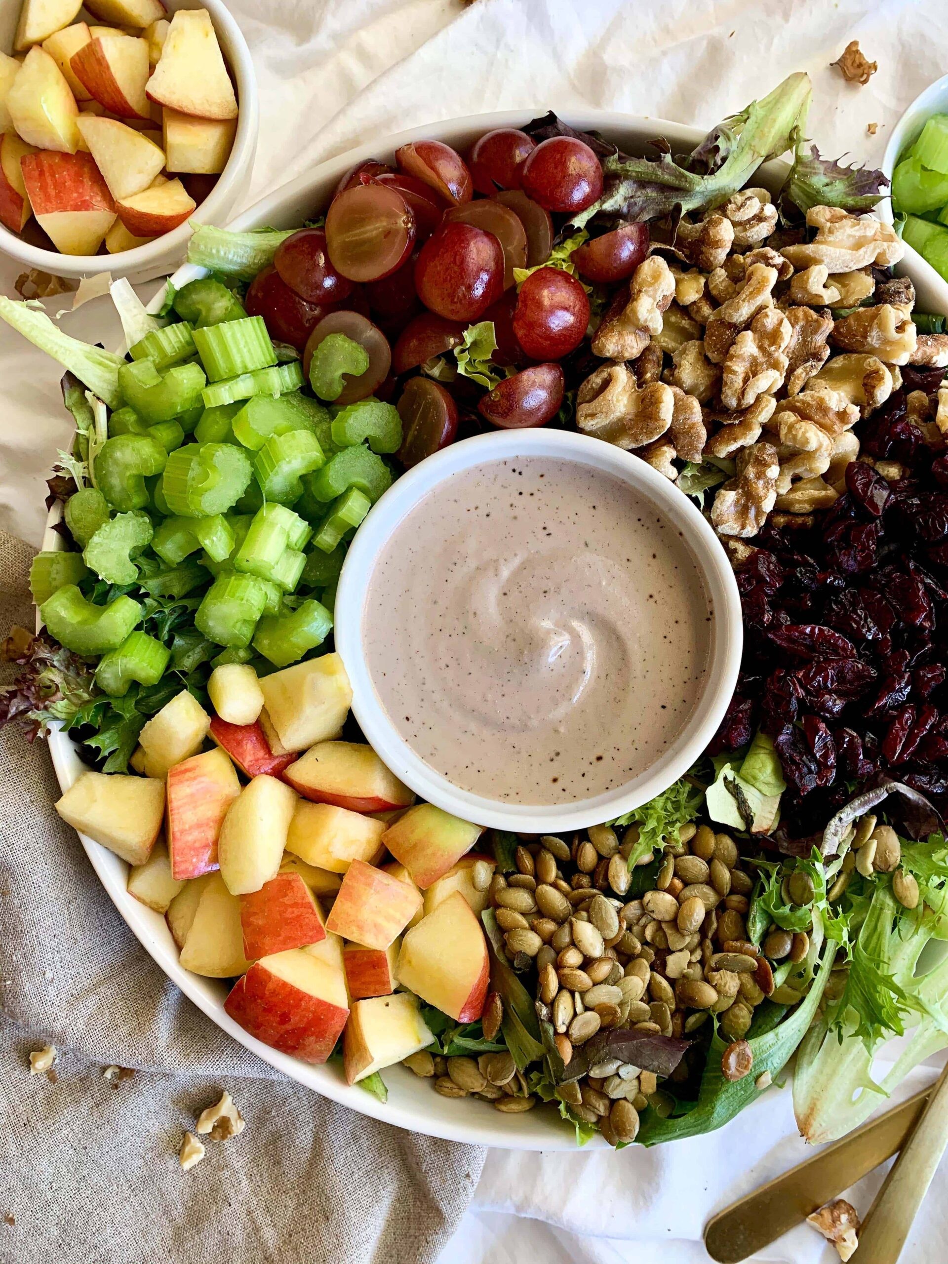 A rustic wooden bowl filled with a vibrant celery root and walnut salad, drizzled with a Dijon vinaigrette