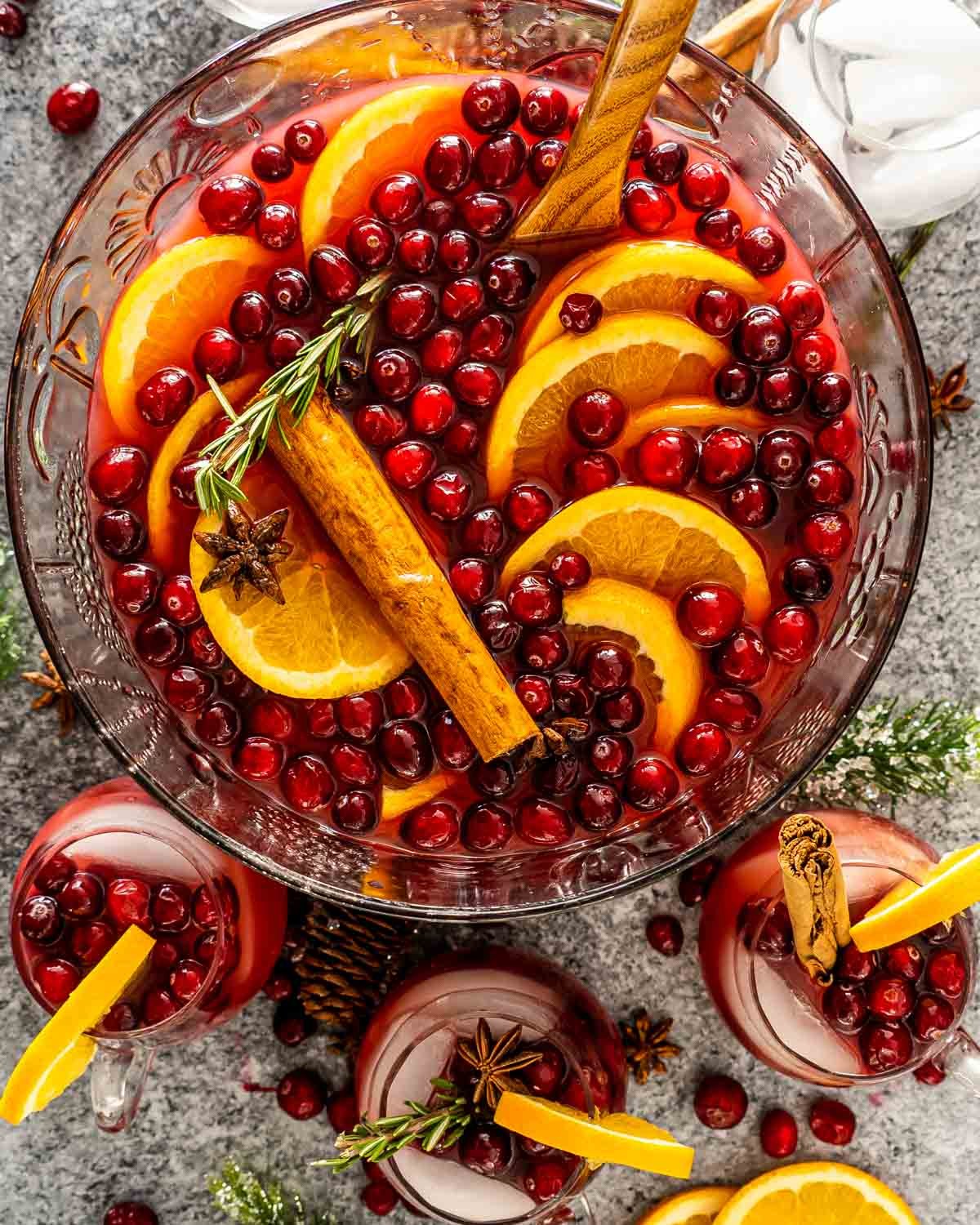steaming orange clove punch in a festive punch bowl with sliced oranges and whole cloves