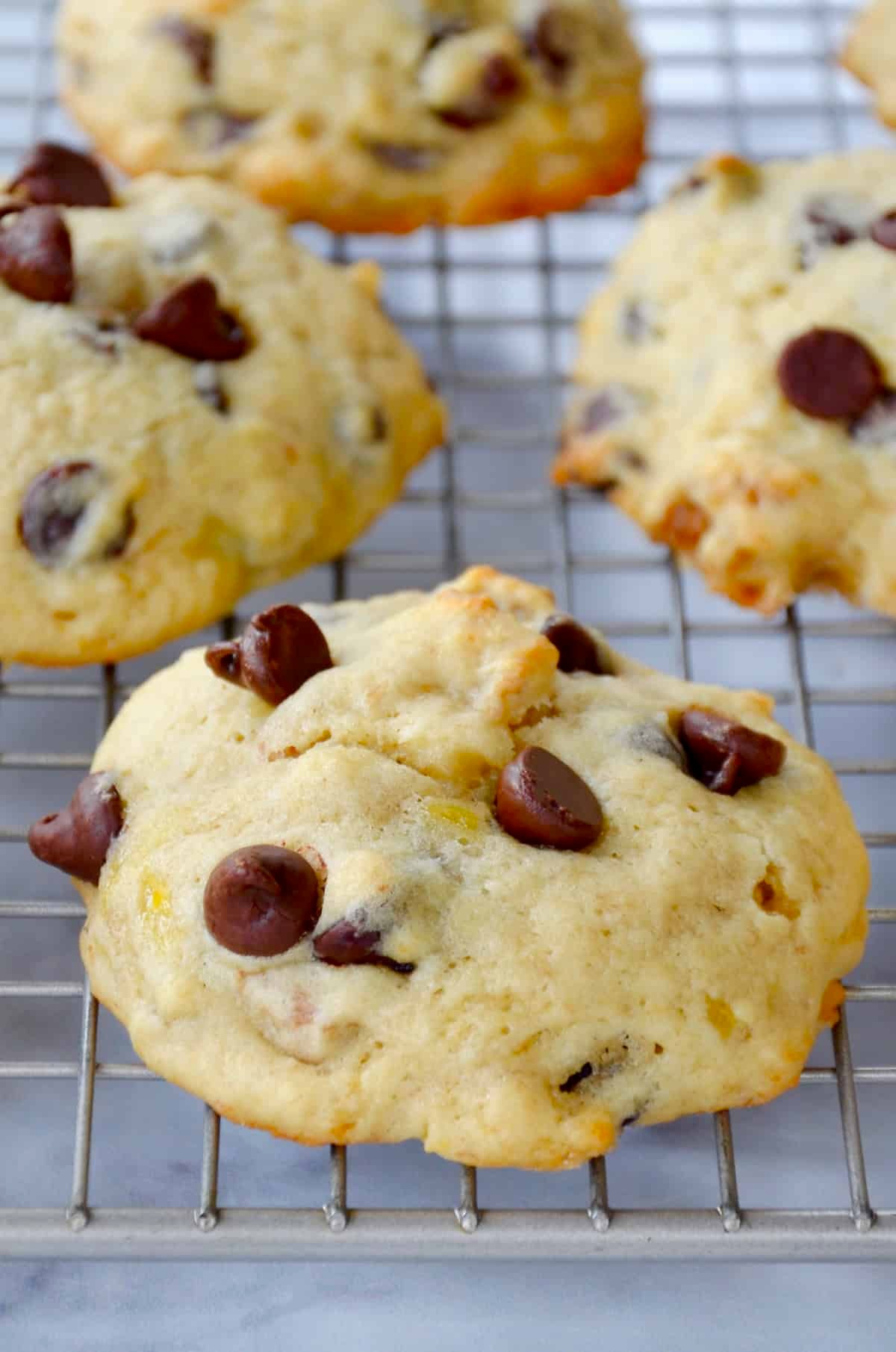 freshly baked banana white chocolate chip cookies on a cooling rack