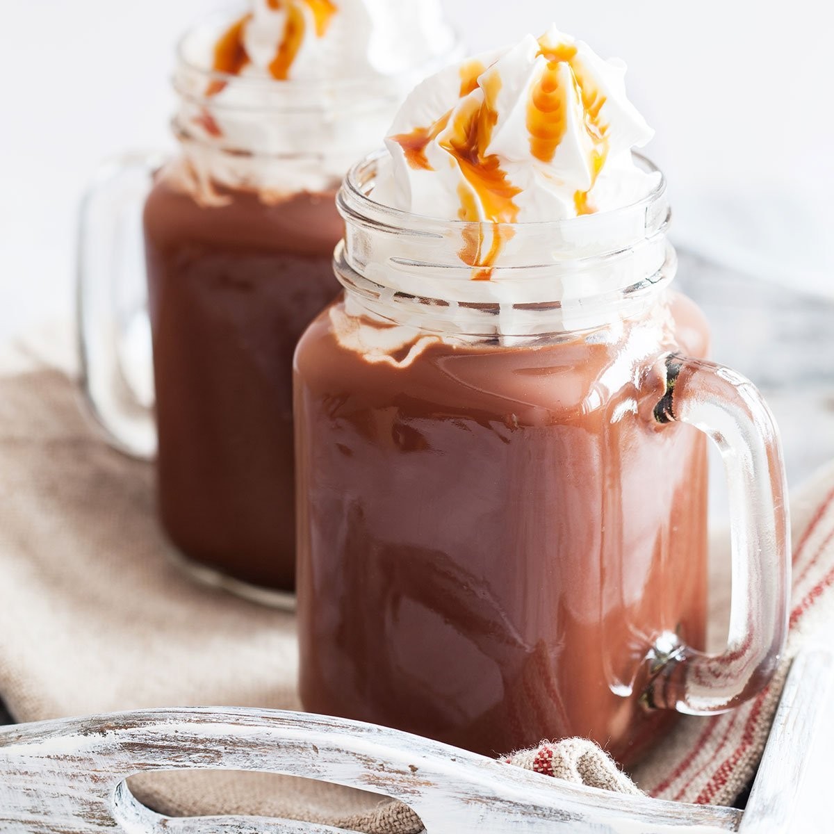 Gourmet hot chocolate with caramel drizzle, whipped cream, and a hint of warmth on a chilly evening