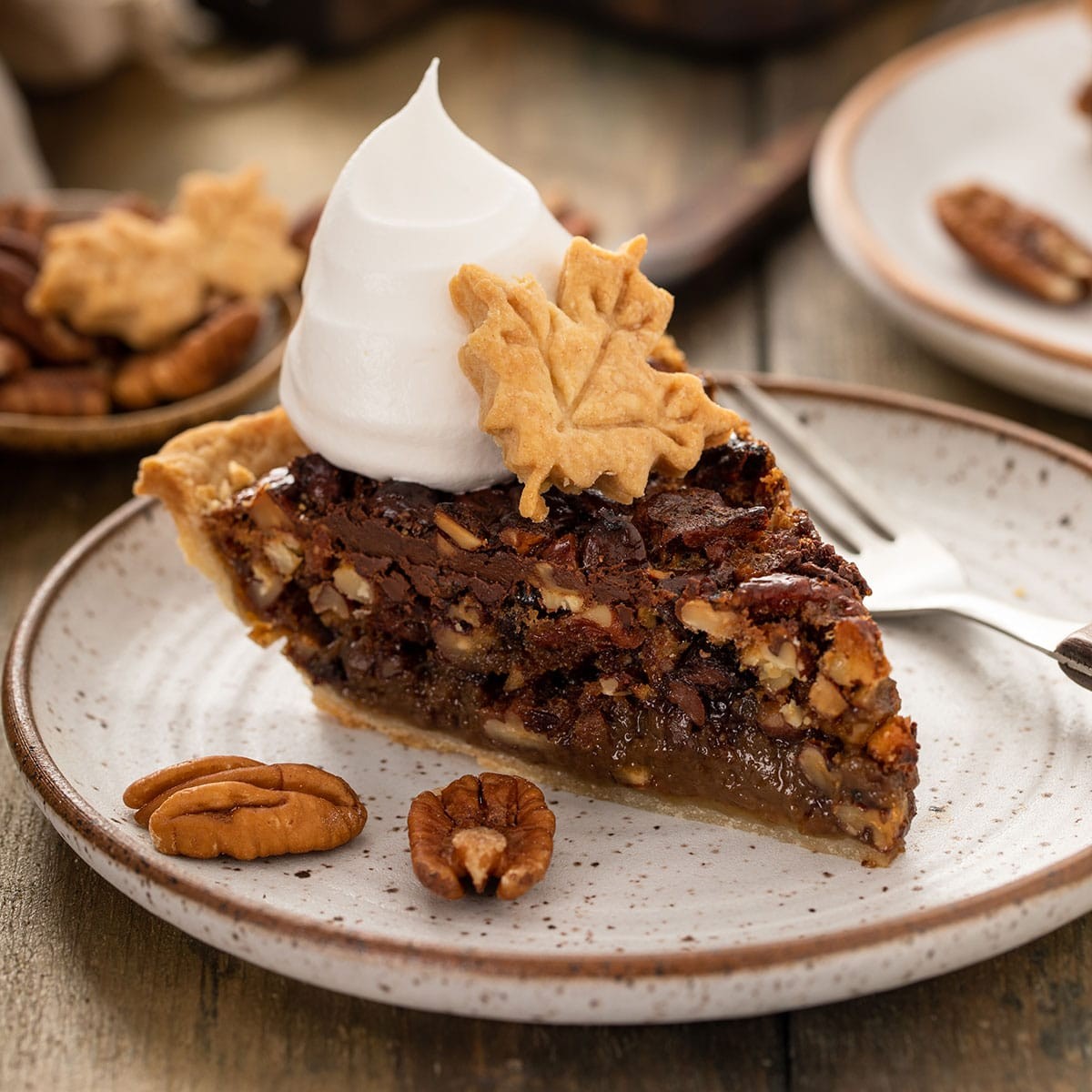 Decadent chocolate pecan pie with a fudgy center, golden crust, sliced with a scoop of vanilla ice cream