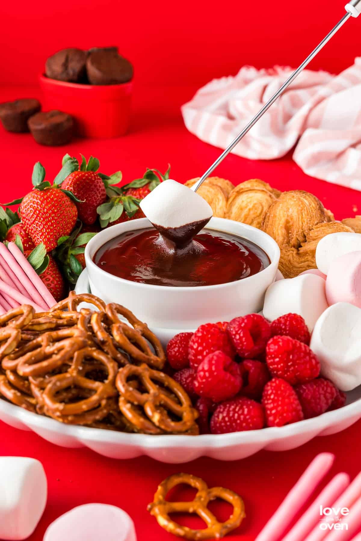 A decadent caramel swirl chocolate fondue with various dippers, like strawberries, marshmallows, and pound cake