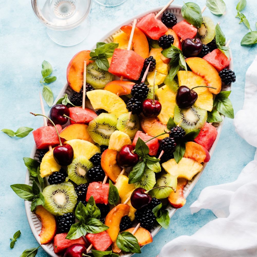 vibrant colorful fruit kebabs on a summer picnic table