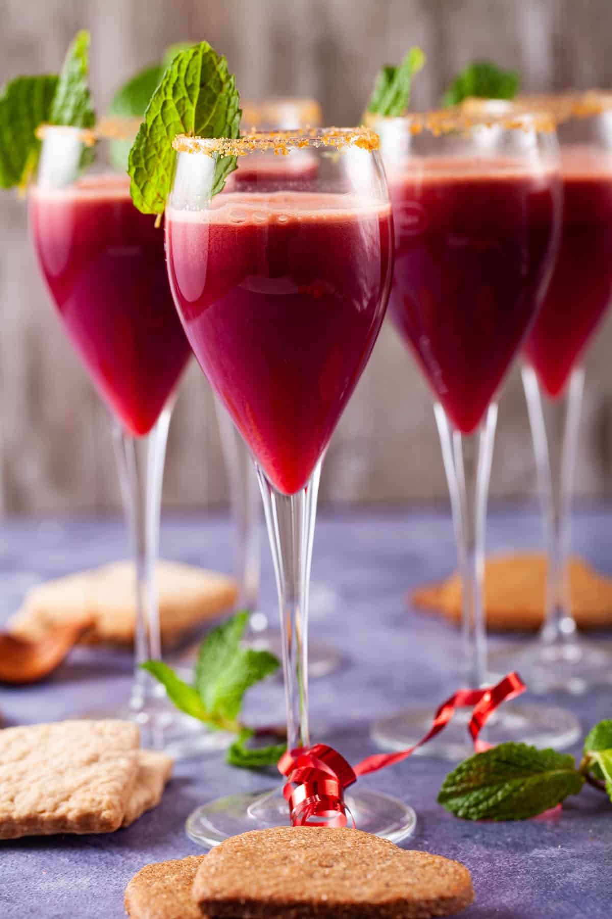 Vibrant sparkling pomegranate mocktail with festive garnishes like rosemary and cranberries in a beautiful glass