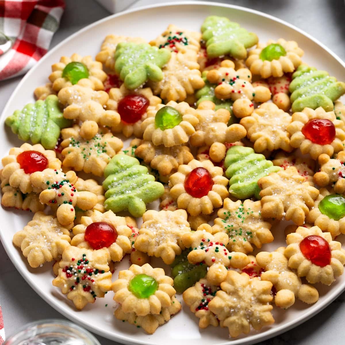 Festive plate of golden butter spritz cookies with a crisp snap, holiday backdrop