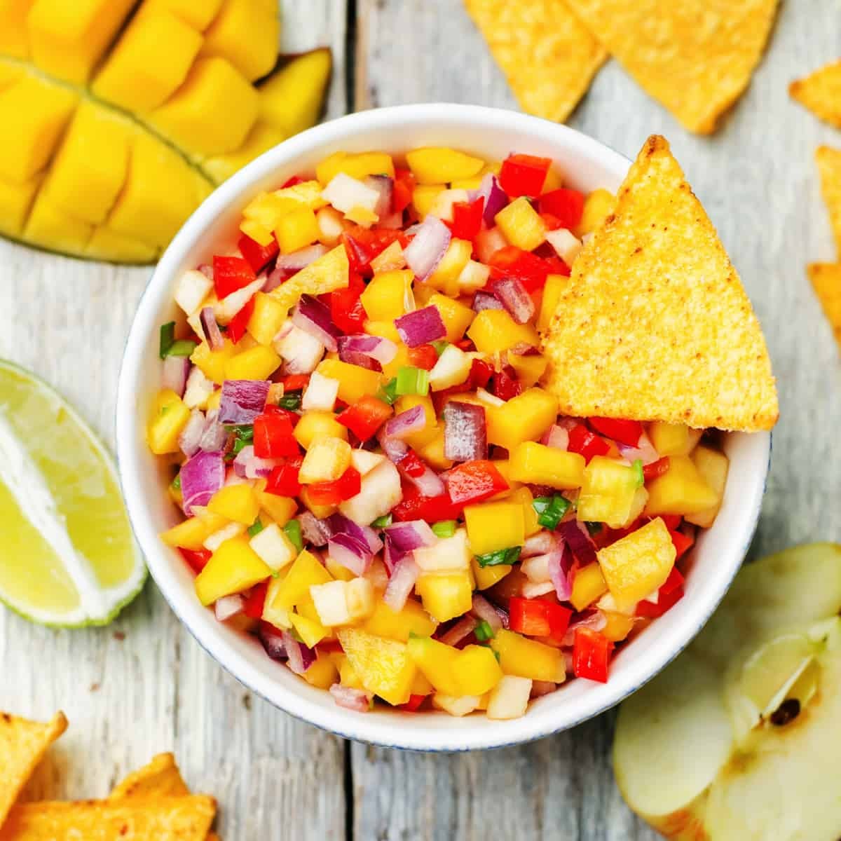 A vibrant bowl of Spicy Mango Fattoush with Chili-Lime Dressing, garnished with fresh herbs and pita chips.