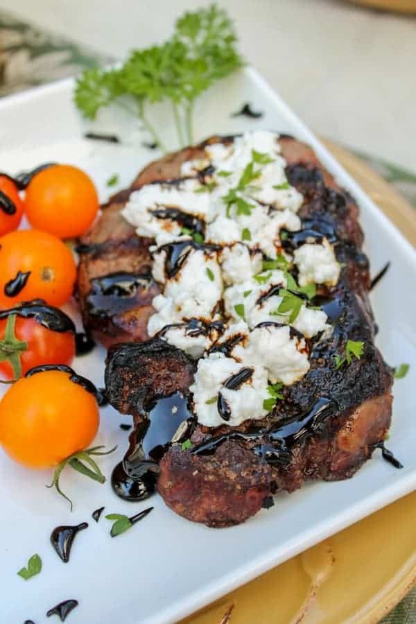 Close-up shot of balsamic glazed köttbullar with goat cheese, garnished with fresh herbs