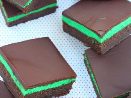 Plate of refreshing mint chocolate squares with a cool bite, garnished with fresh mint and chocolate shavings, dessert photography