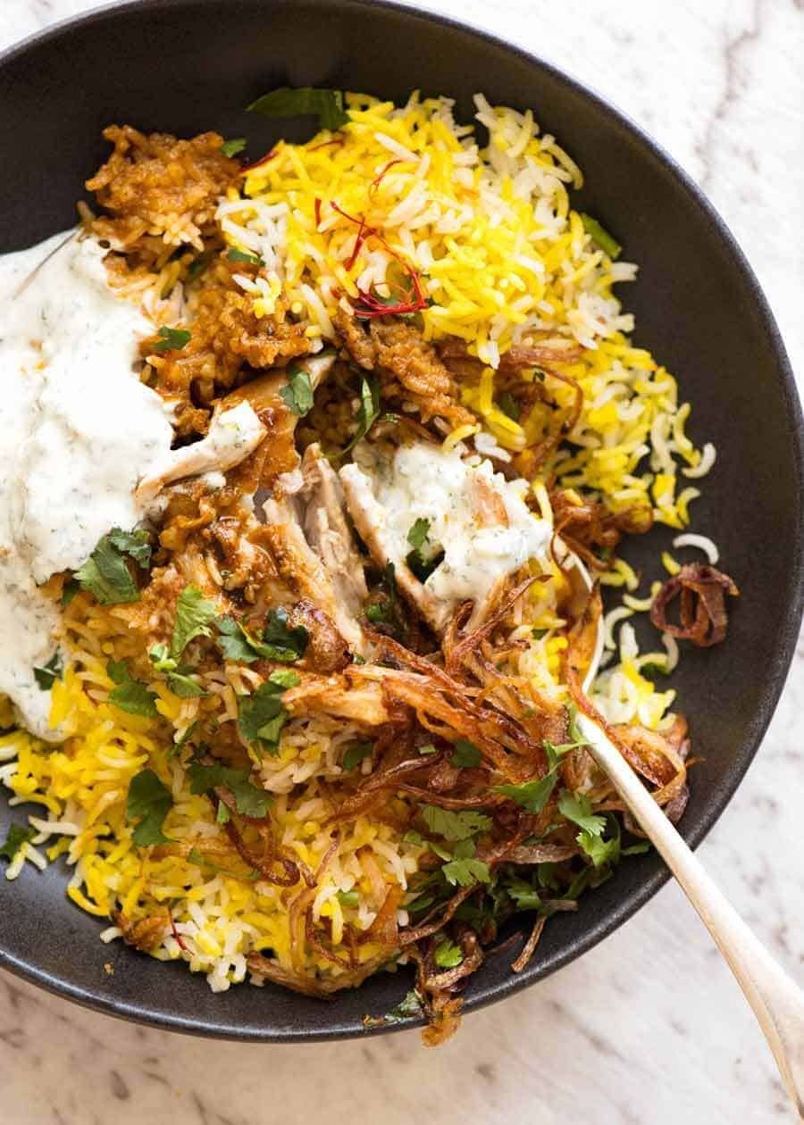 A vibrant, aromatic Spicy Cauliflower & Potato Biryani served in a rustic bowl, garnished with fresh cilantro and fried onions